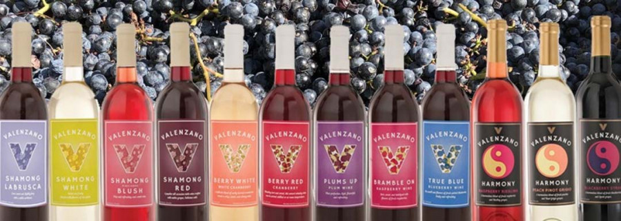 Colorful selection of Valenzano wine bottles against a backdrop of grapes