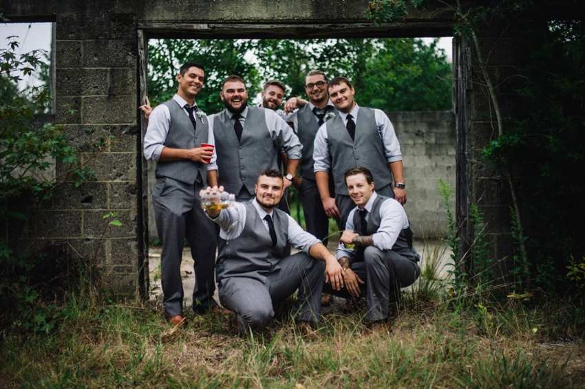Wedding party gathered together at a rustic doorway on the property